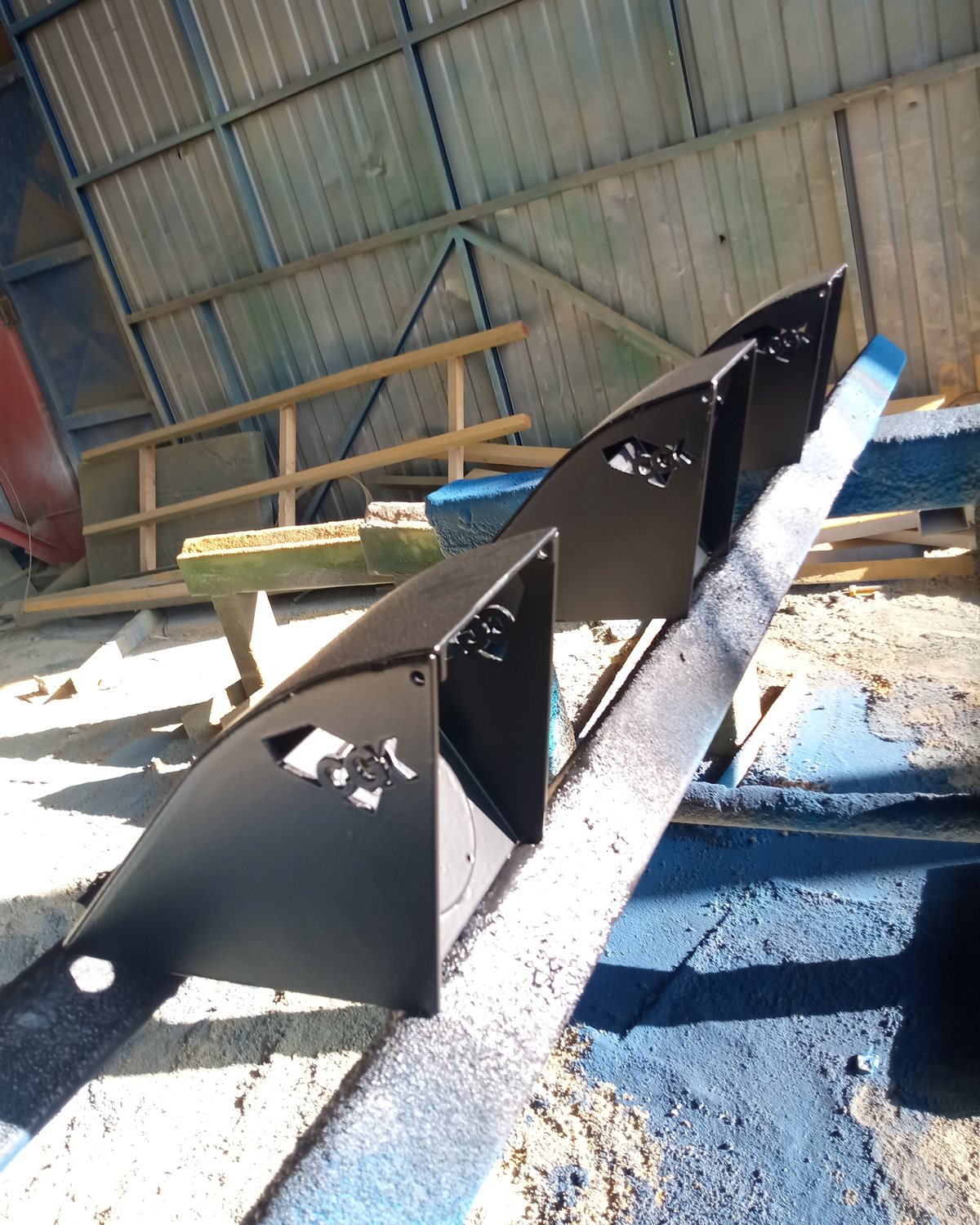 Piezas de acero en proceso de pintura en el taller