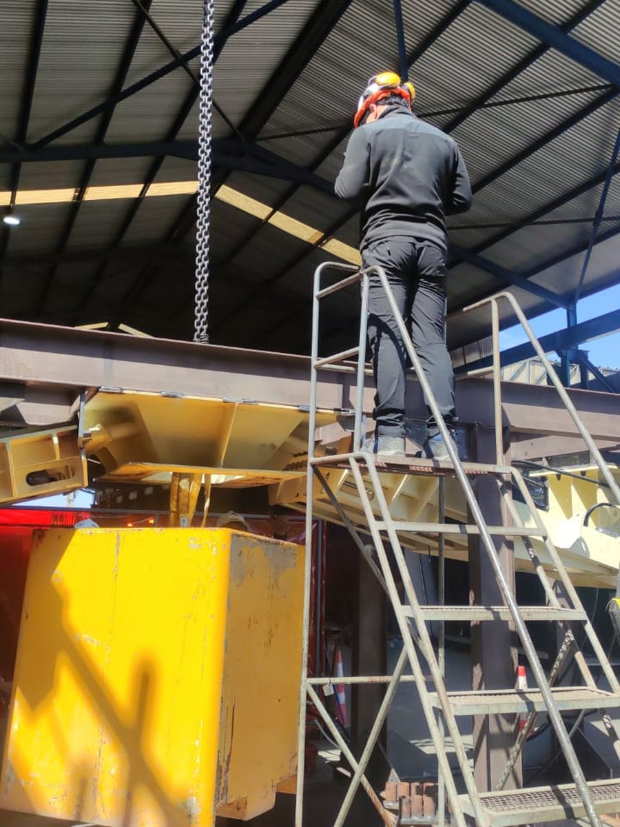 Ensayo de retención en el banco: un contrapeso amarillo suspendido sobre el mecanismo cerrado