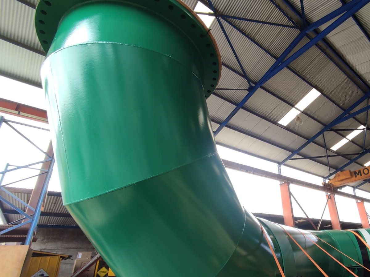 Codo mitrado de 48 pulgadas pintado de verde bajo el puente grúa del taller CGK